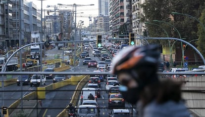 Un ciclista es protegeix de la contaminació davant d'un embús a la Gran Via de Barcelona.