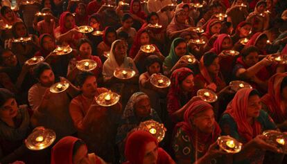 Devotos hindús sujetan lámparas de aceite en el interior de un templo durante el festival Navratri celebrado en Chandigarh (India).