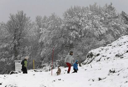 Una familia disfruta de la nieve que ha cubierto las montañas del pirineo navarro.