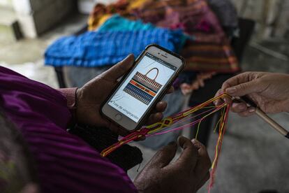 Pascuala López mira el diseño de una bolsa de la marca Christian Dior y lo compara con un cinto elaborado por ella, esta pieza fue denunciada en redes sociales por apropiarse de la iconografía de las artesanas de la zona de Chamula, en Chiapas.