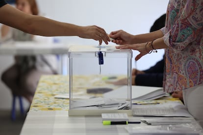 Un votante introduce su papeleta en una urna del colegio electoral Nuestra Señora de la Almudena de Madrid.