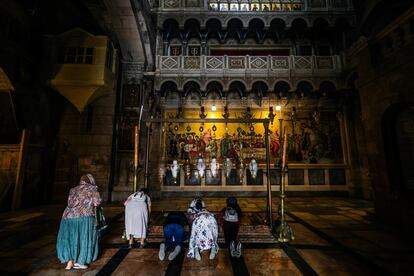 Fieles se reclinan frente a la piedra sobre la que jesucristo fué ungido antes de ser sepultado. Dentro del Santuario del Santo Sepulcro en el barrio viejo de Jerusalén.