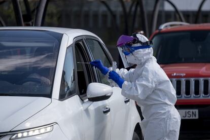 Profissional de saúde aborda uma pessoa em seu próprio veículo para fazer um teste rápido para detectar se está infectada pelo coronavírus, nesta segunda no hospital militar de Sevilha.