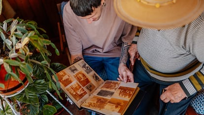 Un nieto viendo un álbum de fotos con su abuelo.