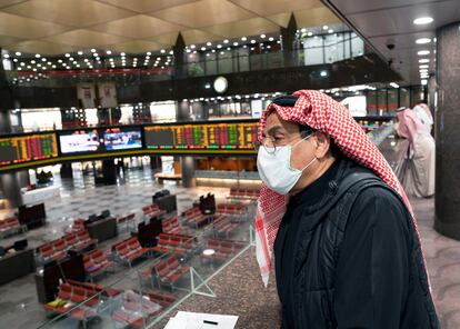 Trabajador con mascarilla en la bolsa de Kuwait.