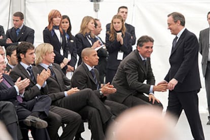 Florentino Pérez estrecha la mano del entrenador, Carlos Queiroz, ante los jugadores, durante el acto celebrado en Madrid.