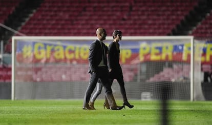 Pep Guardiola y su pareja, Cristina, pasean por el Camp Nou tras el partido contra el Espanyol.