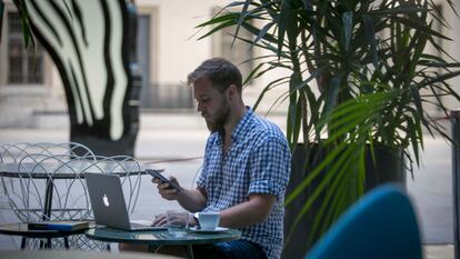 Un joven teletrabaja desde la terraza del restaurante Nubel en el Centro de Arte Reina Sofía.