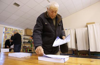 Un hombre coge una papeleta en un colegio antes de votar, en Niza.