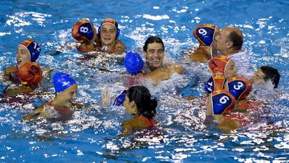 El técnico Miki Oca celebra la victoria en el agua, junto a sus jugadoras.
