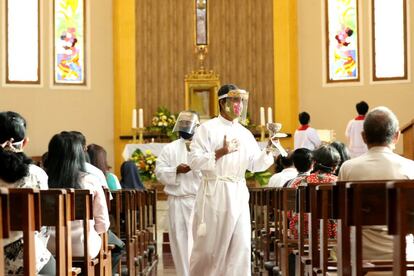 Un sacerdote, con mascarilla y protector facial, en la misa del domingo de Banyuwangi (Indonesia).