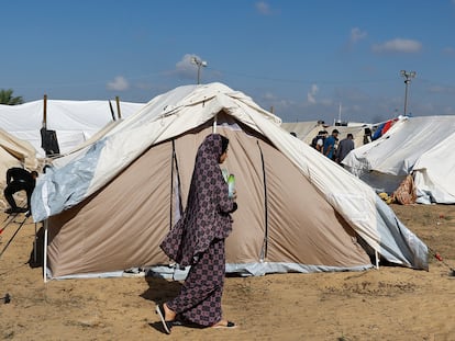 Una mujer pasa delante de una de las tiendas de campaña en el campo de refugiados que la ONU habilitado en Jan Yunis, al sur de la franja de Gaza, este jueves.