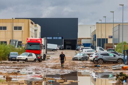 Un hombre camina entre los daños causados por las fuertes lluvias en el polígono industrial de Toledo.