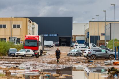 Un hombre camina entre los daños causados por las fuertes lluvias en el polígono industrial de Toledo. 