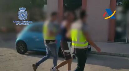 Dos agentes escoltan a uno de los detenidos en la Opreación Aladín.