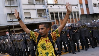 Manifestante diante de um cordão policial em São Paulo.