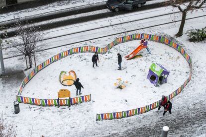 Uma família brinca na neve em um parque infantil de Zaragoza.