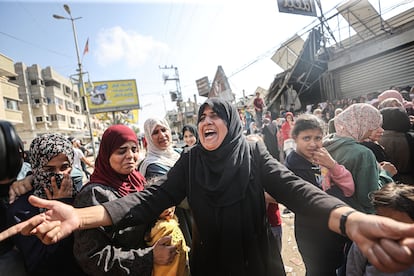 Una multitud hace cola para comprar en una panadería parcialmente destruida por un ataque israelí, este jueves, en el campo de refugiados de Nuseirat en Deir al-Balah.