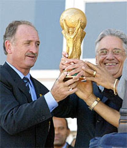 Luiz Felipe Scolari (izqda.) ofrece al presidente Cardoso la Copa del Mundo.