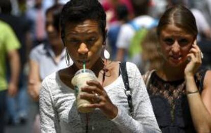 Una mujer bebe una bebida de tamaño gigante por las calles de Nueva York, Estados Unidos.