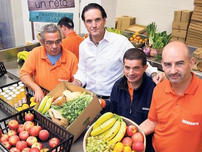 Eduardo Petrossi, consejero delegado de Mahou-San Miguel, con las personas que preparan las cestas de frutas y verduras que cultivan en la Fundación Juan XXIII, donde es voluntario.