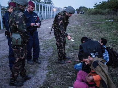 Policies i soldats comproven la documentació de diversos refugiats a la frontera entre Sèrbia i Hongria, el 15 de setembre del 2015.