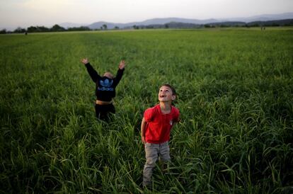 Dos niños miran hacia el cielo mientras juegan en el campo de refugiados de Idomeni (Grecia).