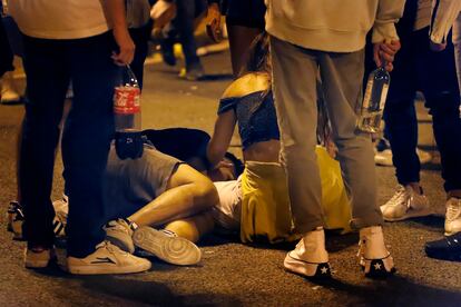 Un joven es atendido por sus amigos en un botellón en Maria Cristina, durante La Mercè.