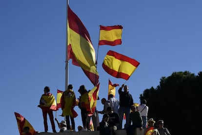 Manifestantes sostienen banderas de España.