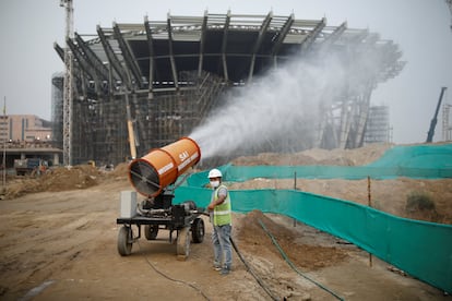 Un trabajador usa una dispositivo que nebuliza agua para tratar de bajar a tierra las particulas contaminantes junto a una obra en la capital india, Nueva Delhi, en 2020.