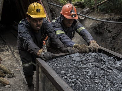 Dos mineros empujando un vagón de carbón afuera de una mina en Cucunuba (Colombia)