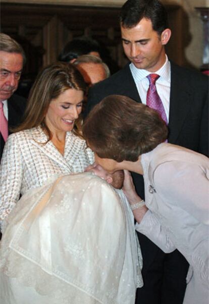 La Reina besa a su nieta la infanta Leonor de Todos los Santos, en brazos de su madre la princesa Letizia, y junto al príncipe Felipe, tras el bautizo oficiado este mediodía por el arzobispo de Madrid, el cardenal Antonio María Rouco Varela, en el vestíbulo del Palacio de la Zarzuela.