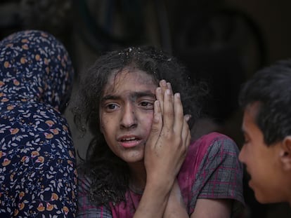 Una joven palestina herida en un ataque israelí es atendida por sus familiares en el campo de refugiados de Nuseirat, en el centro de Gaza.