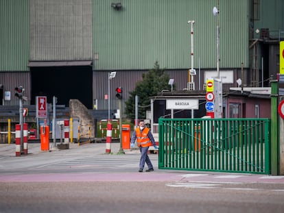 Un trabajador cierra la entrada de una fábrica, el 15 de marzo en Santander.