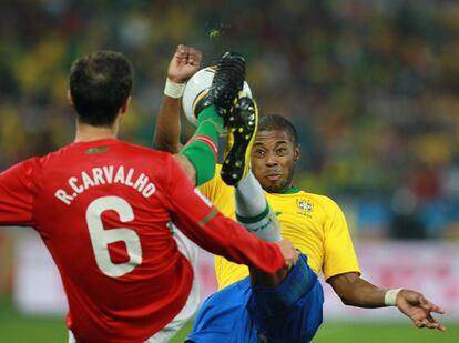 El defensa portugués Ricardo Carvalho y el defensa Michel Bastos pelean por un balón.