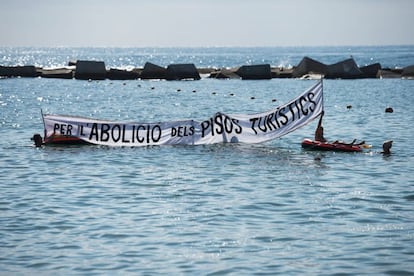 Unos manifestantes despliegan una pancarta dentro del mar mientras el tradicional cañón con el que los vecinos descargan su ira en las protestas vecinales vomita un par de sonoros petardos.