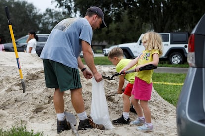 Una familia rellena bolsas de arena mientras se preparan para la llegada del huracán Milton el lunes en St. Petersburg, Florida (Estados Unidos). 