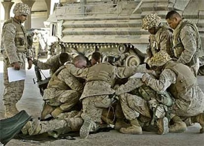 Un grupo de <i>marines</i> reza el jueves ante el cuerpo de un compañero muerto en la batalla de Faluya.