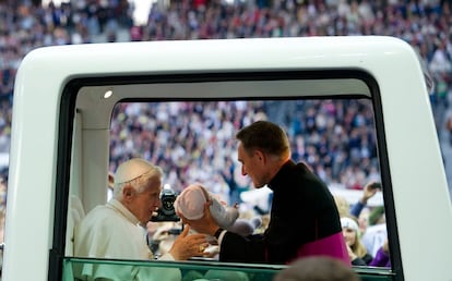 Benedicto XVI sujeta a un bebé para darle su bendición a su llegada al Estadio Olímpico de Berlín.