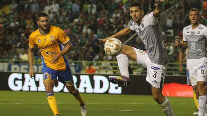 Guillermo Burdisso, del León, despeja ante la mirada de Pierre Gignac.