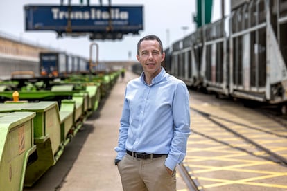 Carlos Pereda, subdirector de Tramesa, en el Puerto de Valencia junto al tren que traslada los camiones desde Valencia a Madrid.