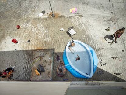 Unos niños se bañan en una piscina colocada en el barrio de las Tres Mil Viviendas de Sevilla en el primer día de la ola de calor.