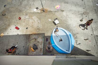 Unos niños se bañan en una piscina colocada en el barrio de las Tres Mil Viviendas de Sevilla en el primer día de la ola de calor.