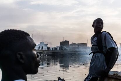 Dos jóvenes y el puento sobre el Senegal, al fondo, en Saint Louis.