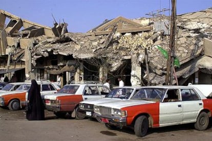 Taxis detenidos ante varios edificios destruidos por bombardeos estadounidenses en Faluya.