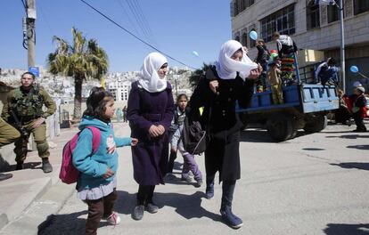 Colegialas palestinas junto a colonos israelíes durante las celebraciones de la fiesta judía de Purim en la zona ocupada de la ciudad cisjordana de Hebrón.