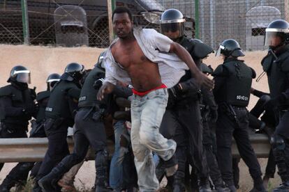 Un inmigrante subsahariano logra saltar la valla de Melilla en 2014.