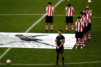 El árbitro Daudén Ibáñez y juveniles del Athletic en el minuto de silencio en recuerdo de Zarra.