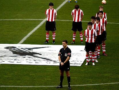 El árbitro Daudén Ibáñez y juveniles del Athletic en el minuto de silencio en recuerdo de Zarra.