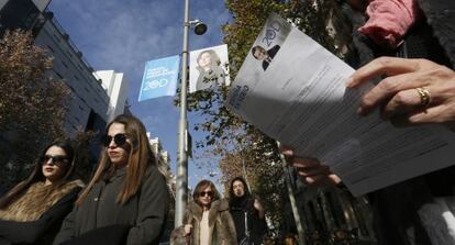 Una mujer lee una información electoral de Rajoy en el Barrio Salamanca.